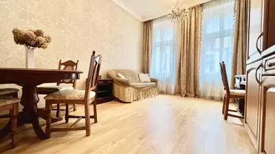 a living room with a table and chairs and a couch at Stylish riverside apartment in Prague