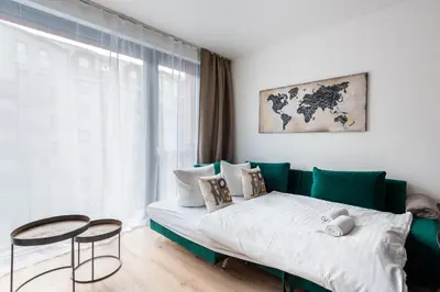a bedroom with a green couch and a table at Jay Apartments in Prague