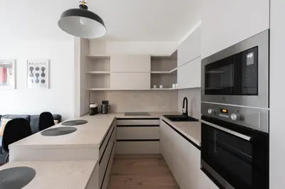 a white kitchen with a black and white appliances at Jay Apartments in Prague