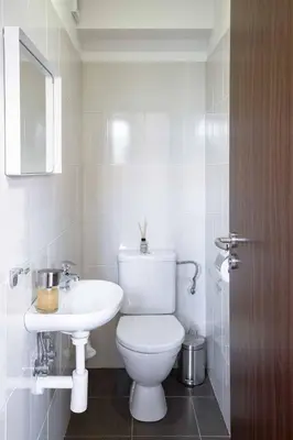 a bathroom with a white toilet and a sink at 150m² 4BR Duplex Near Metro & Prague Center in Prague