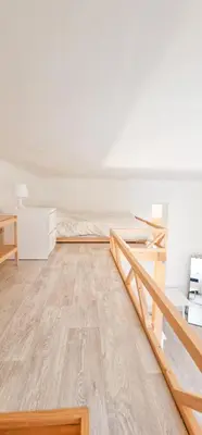 a bedroom with two beds and a wooden floor at Cozy Karlín Loft City Center in Prague