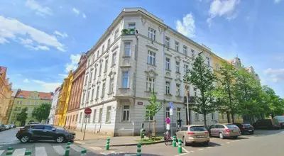 a large white building with cars parked in front of it at Cozy Karlín Loft City Center in Prague