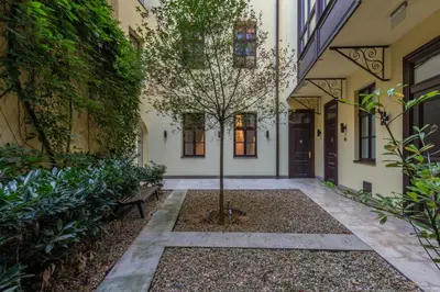 a courtyard with a tree in the middle of a building at Upscale apartments in prime location near all sights in Prague