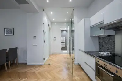 a kitchen with white walls and a wooden floor at Upscale apartments in prime location near all sights in Prague
