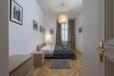 a bedroom with a bed and a chandelier at Upscale apartments in prime location near all sights in Prague