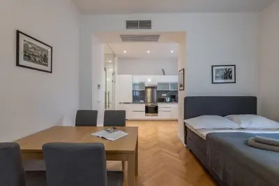 a bedroom with a bed and a table and a kitchen at Upscale apartments in prime location near all sights in Prague