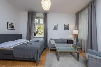 a bedroom with a bed and a couch and a table at Upscale apartments in prime location near all sights in Prague
