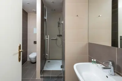 a bathroom with a shower and a sink and a toilet at Upscale apartments in prime location near all sights in Prague