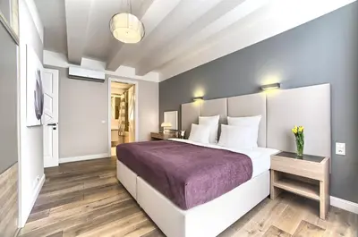 a bedroom with a large bed with a purple blanket at Exclusive 2 bedroom apartment Old Town - 2 baths, balcony and view - by Prague City Apartments in Prague
