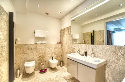 a bathroom with a sink and a toilet and a mirror at Exclusive 2 bedroom apartment Old Town - 2 baths, balcony and view - by Prague City Apartments in Prague