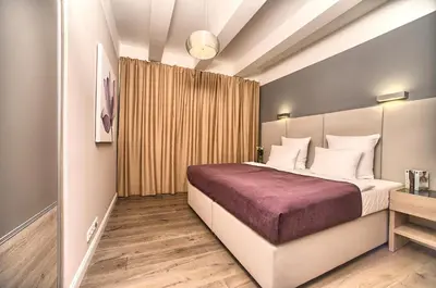 a bedroom with a large bed with a purple blanket at Exclusive 2 bedroom apartment Old Town - 2 baths, balcony and view - by Prague City Apartments in Prague