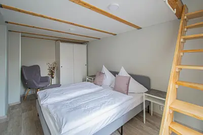 a bedroom with a bed with white sheets and pink pillows at Sightseeing apartment by Ruterra in Prague