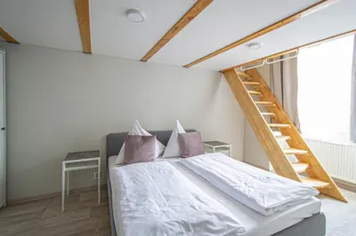 a bedroom with a bed with a ladder on the wall at Sightseeing apartment by Ruterra in Prague