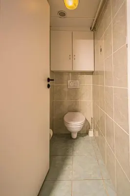 a bathroom with a toilet and a white cabinet at Sightseeing apartment by Ruterra in Prague
