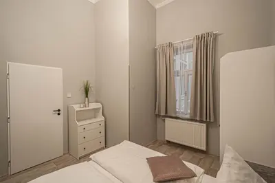 a white bedroom with a bed and a window at Sightseeing apartment by Ruterra in Prague