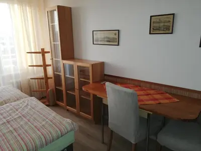 a room with a wooden table and a bed at Terrace Studio Prague Center in Prague