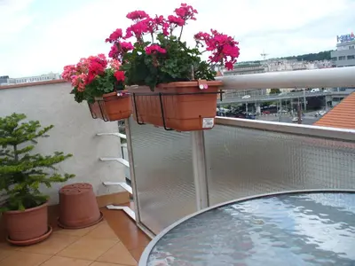a balcony with two planters with flowers on it at Terrace Studio Prague Center in Prague