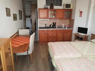 a small kitchen with a table and a bed at Terrace Studio Prague Center in Prague