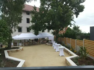 a group of white tables and chairs in front of a building at Relax apartmán na Mlejnici in Nové Strašecí