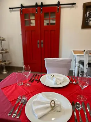 a table with a red table cloth with plates and silverware at Relax apartmán na Mlejnici in Nové Strašecí