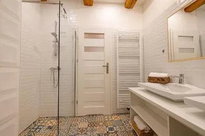 a white bathroom with a shower and a sink at Relax apartmán na Mlejnici in Nové Strašecí
