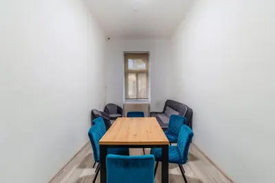 a conference room with a wooden table and blue chairs at Hostel Comfort in Prague