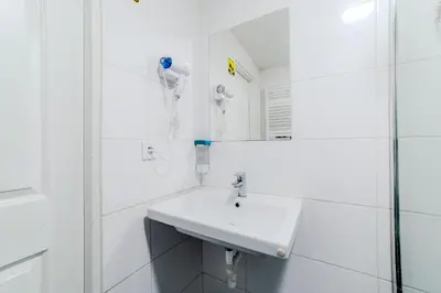 a white bathroom with a sink and a mirror at Hostel Comfort in Prague