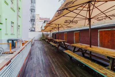 a row of wooden benches with umbrellas on a deck at Hostel Comfort in Prague