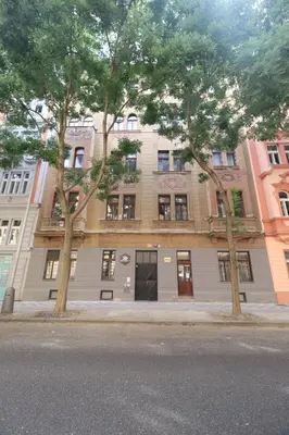 a building on a street with trees in front of it at Hostel Comfort in Prague