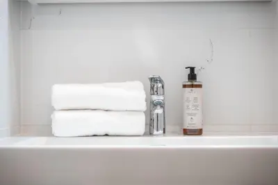 a bathroom sink with towels and a bottle of soap at Majestic Square View Residence in Prague