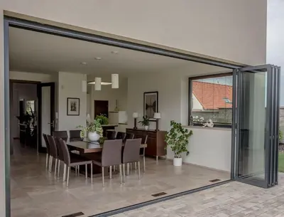 a dining room and living room with a table and chairs at Luxury villa near Prague with pool and tennis court in Čestlice