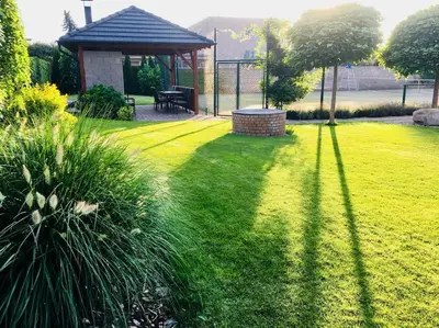 a green lawn with a gazebo and a bench at Luxury villa near Prague with pool and tennis court in Čestlice