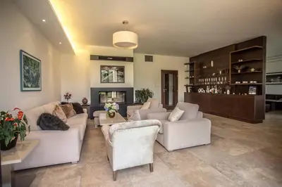 a living room with white couches and a fireplace at Luxury villa near Prague with pool and tennis court in Čestlice