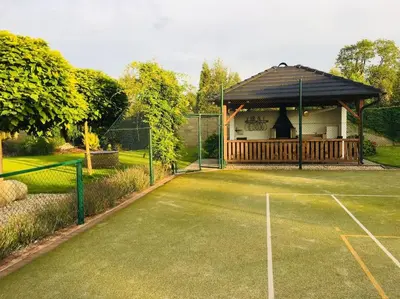 a tennis court with a pavilion with a tennis court at Luxury villa near Prague with pool and tennis court in Čestlice