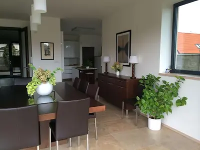 a dining room with a table and chairs and plants at Luxury villa near Prague with pool and tennis court in Čestlice