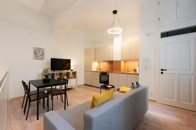 a living room and kitchen with a couch and a table at Eclectic and design duplex in Prague in Prague
