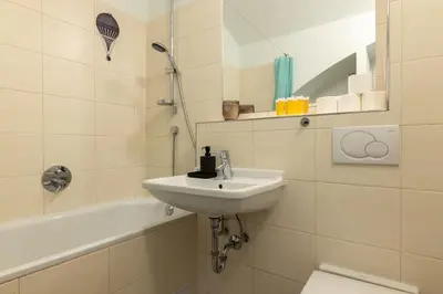a bathroom with a sink and a toilet and a tub at Eclectic and design duplex in Prague in Prague