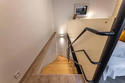 a staircase in a room with white walls and wooden floors at Eclectic and design duplex in Prague in Prague