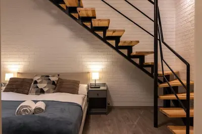 a bedroom with a bed and a staircase at Eclectic and design duplex in Prague in Prague