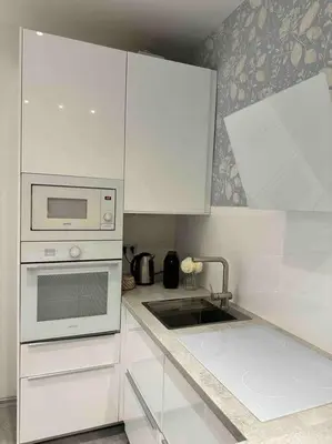 a kitchen with white cabinets and a sink and a microwave at Home away from home in Prague
