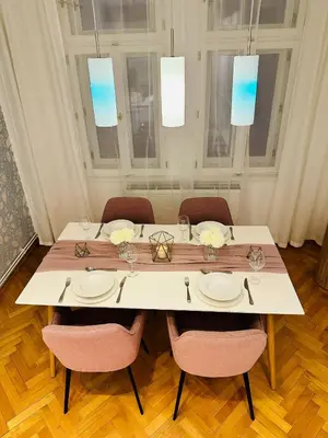 a dining room table with chairs and a white table at Home away from home in Prague