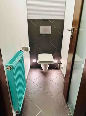 a small bathroom with a toilet and a tiled floor at Home away from home in Prague