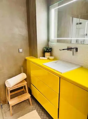 a yellow bathroom with a sink and a stool at Home away from home in Prague
