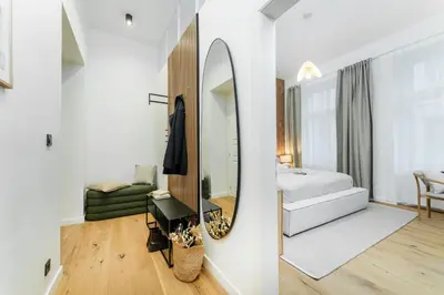 a bedroom with a mirror and a bed and a couch at Rentero Cozy Wenceslas square 700m Apartment, Prague in Prague