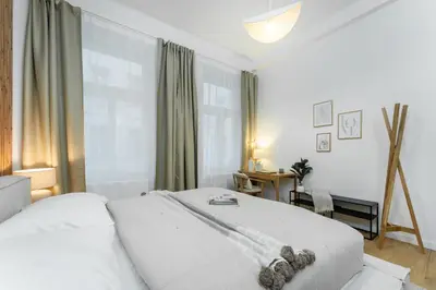 a white bedroom with a bed and a desk at Rentero Cozy Wenceslas square 700m Apartment, Prague in Prague