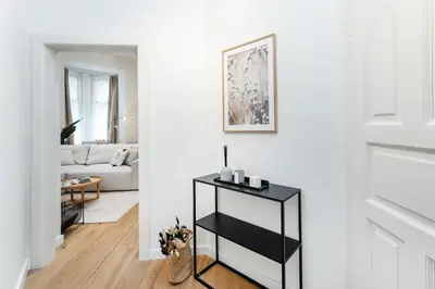 a living room with a black console table in a white room at Rentero Cozy Wenceslas square 700m Apartment, Prague in Prague