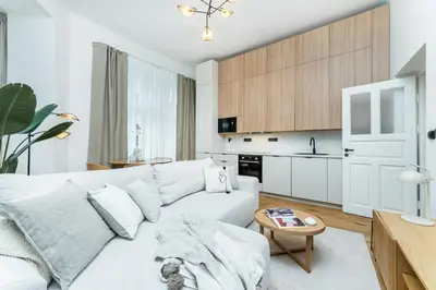 a living room with a white couch and a kitchen at Rentero Cozy Wenceslas square 700m Apartment, Prague in Prague