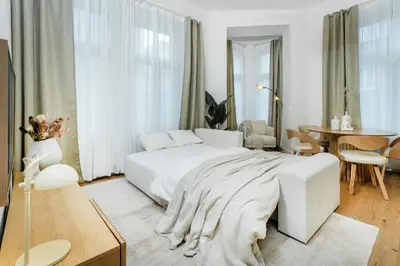 a bedroom with a white bed and a table at Rentero Cozy Wenceslas square 700m Apartment, Prague in Prague