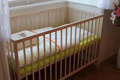 a crib with a mattress in a room at Royal Prague Apartment Celakovskeho Sady in Prague