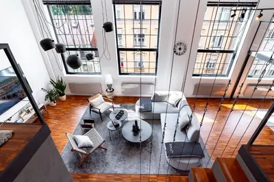 a living room with couches and chairs and windows at The Factory Loft Prague in Prague